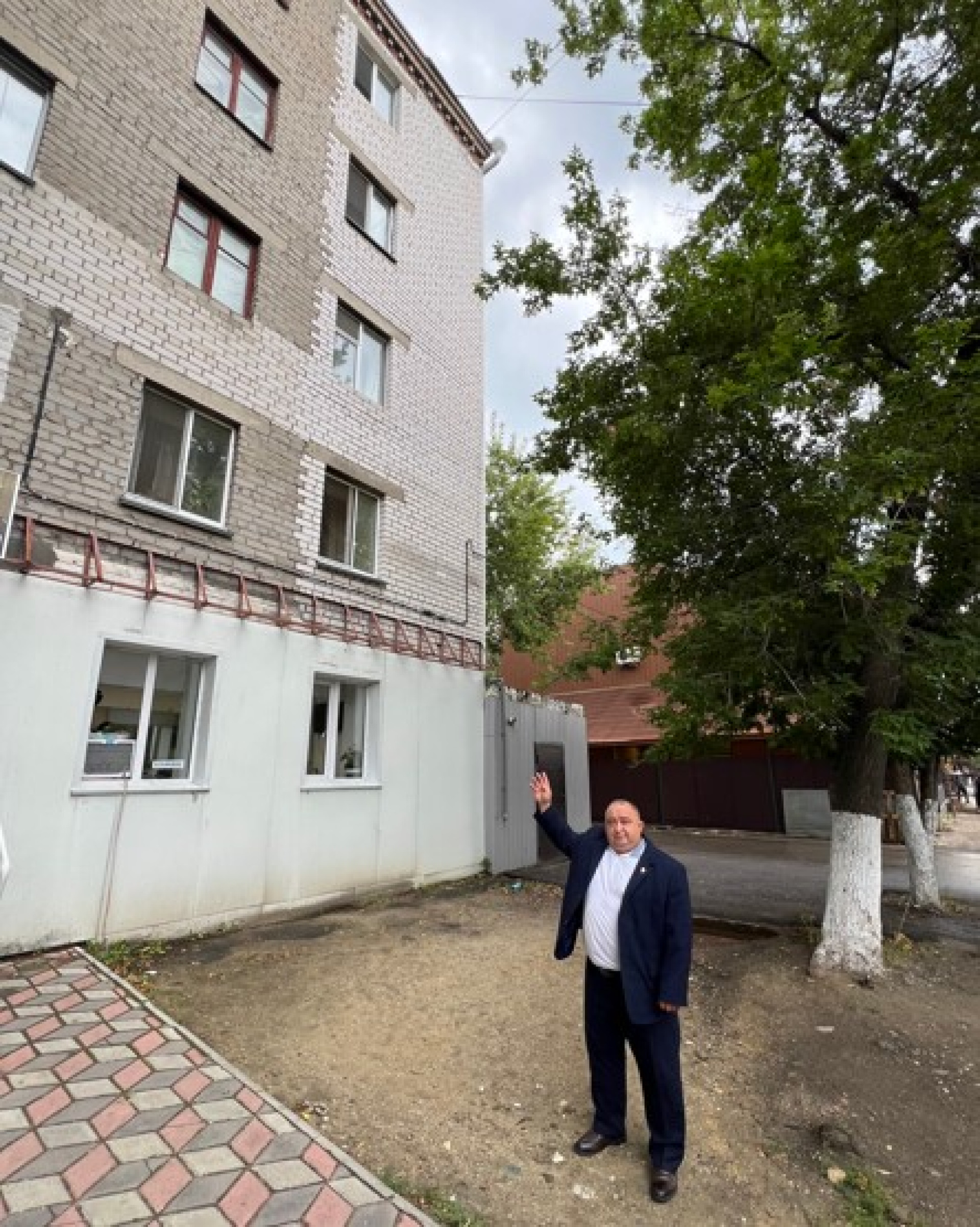 Ветеран криминалистики Игорь Семёнов показывает на окно, откуда осуждённый Зуденков выбросил девочку. Фото:©️ Tengrinews.kz / Елена Бережная