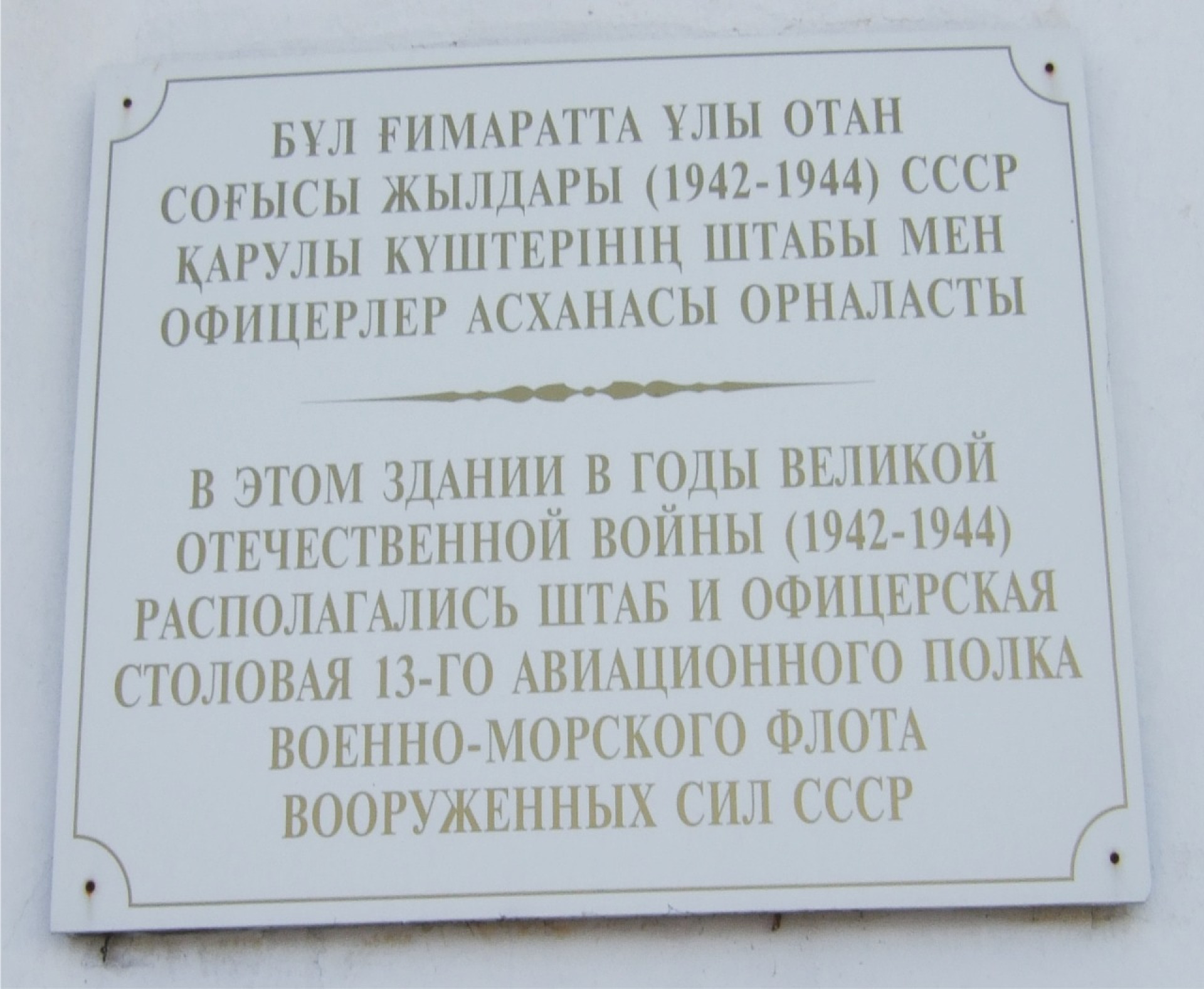 Памятная табличка на здании в Тайынше: "В этом здании в годы Великой Отечественной войны (1942-1944) располагались штаб и офицерская столовая 13-го авиационного полка военно-морского флота Вооруженных сил СССР".