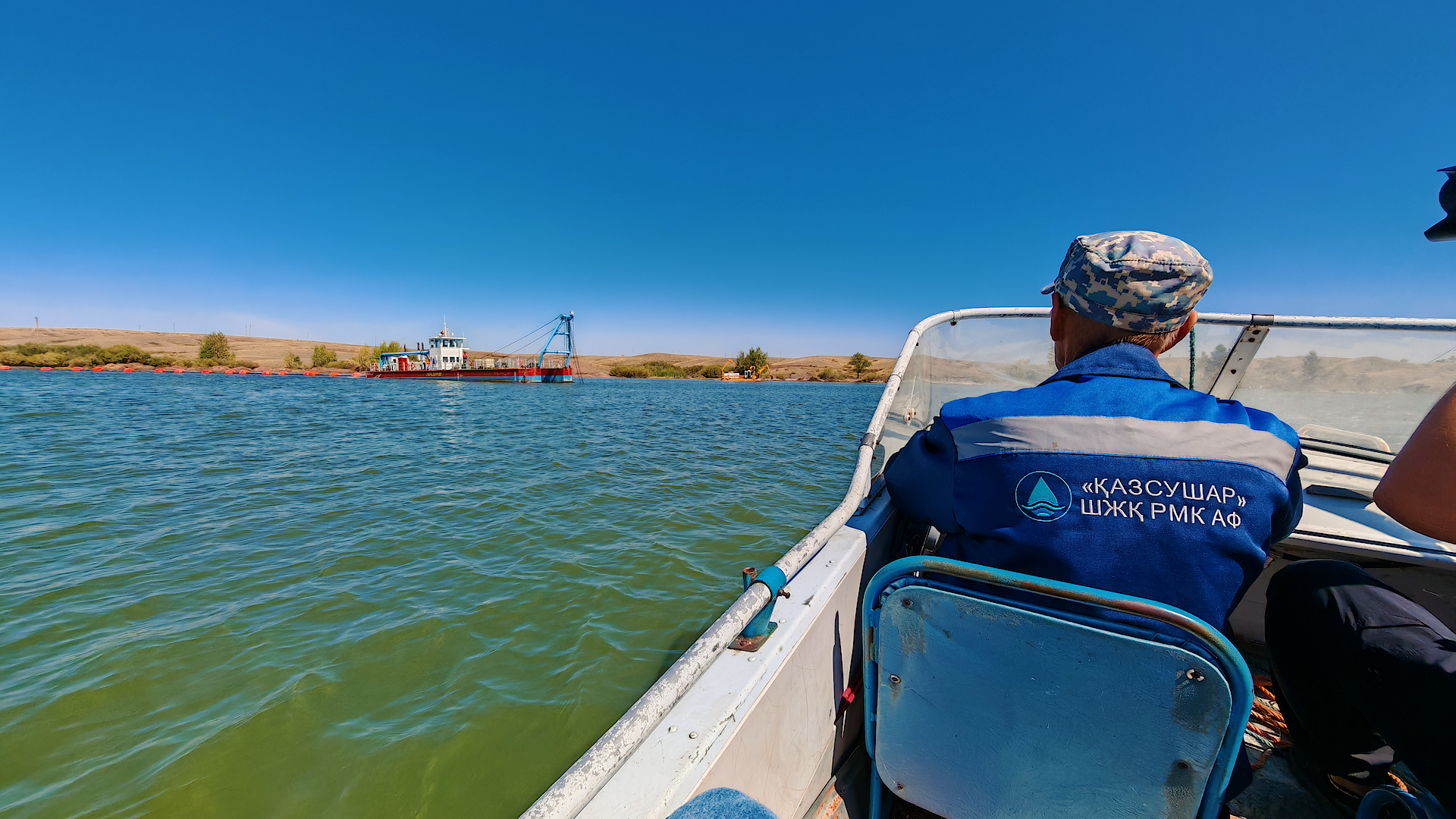 Моторная лодка везёт журналистов к земснаряду, Астанинское водохраналище