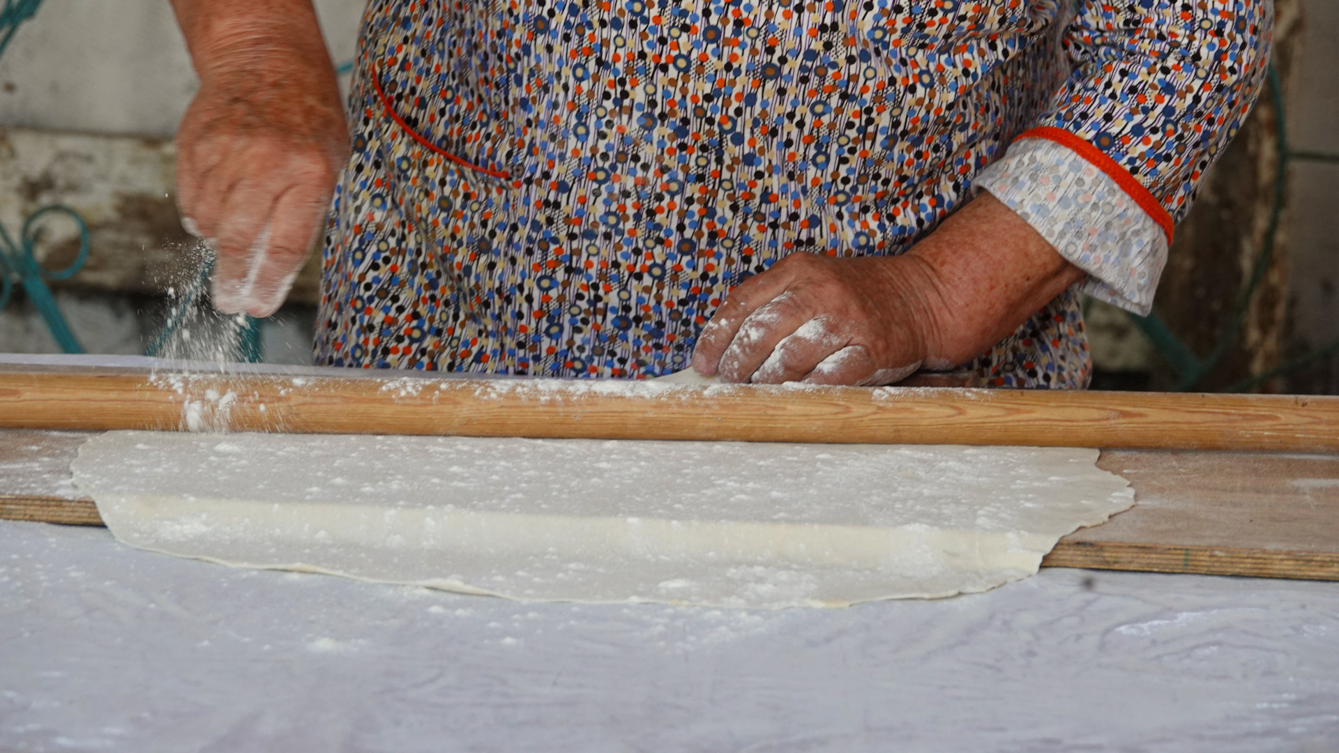 Женщина раскатывает тесто