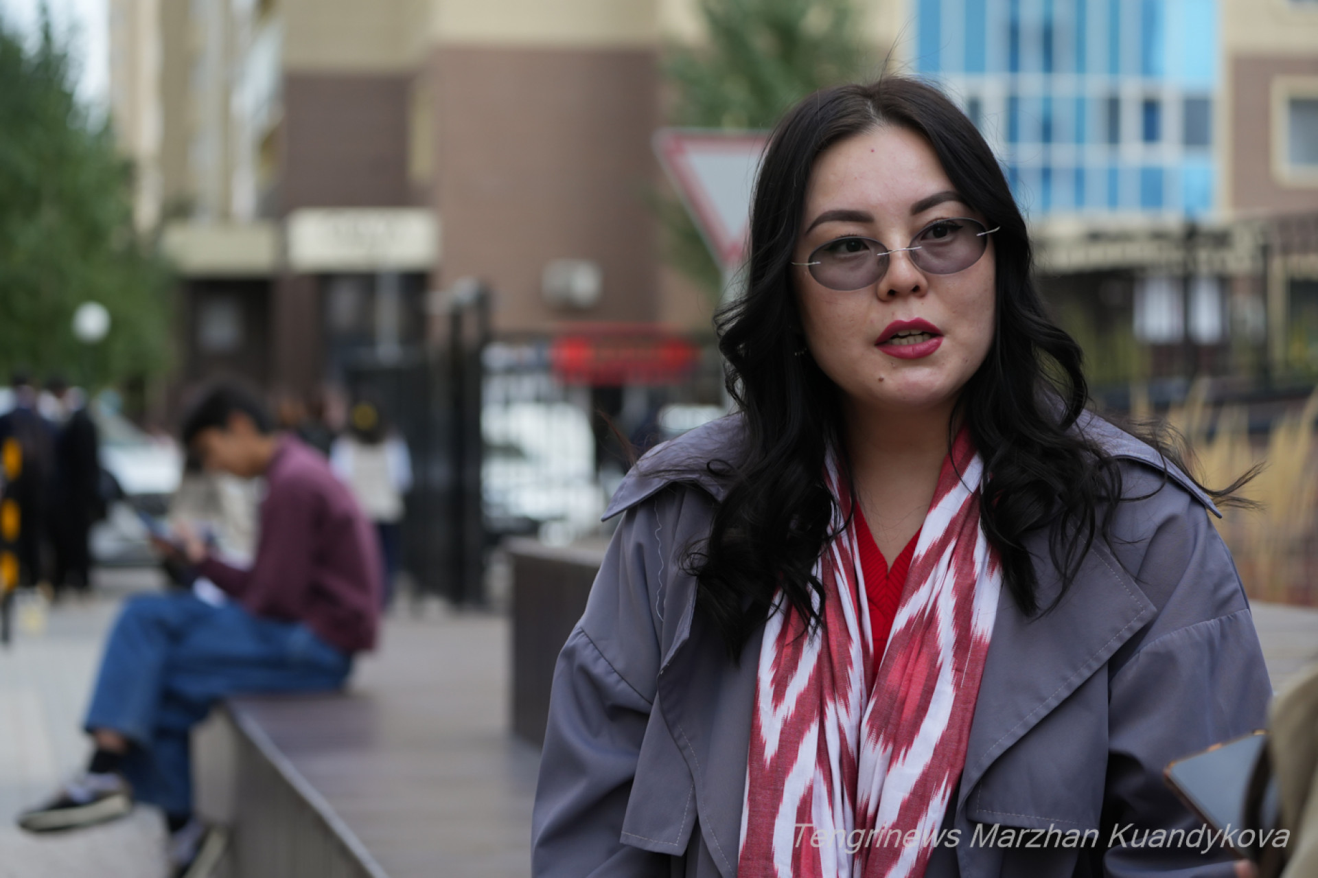 Девушка сидит на скамейке в парке