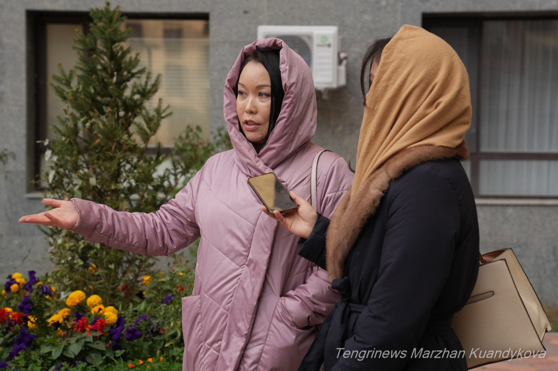 Журналист берет комментарий у женщины во дворе