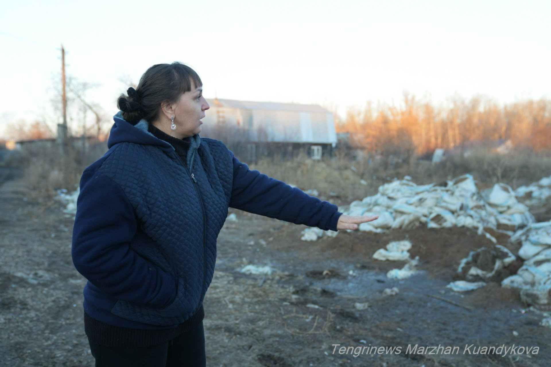 Екатерина Ткаченко, жительница Заречного, показывает дамбу из мешков с песком, которыми они пытались спасти посёлок от паводка.