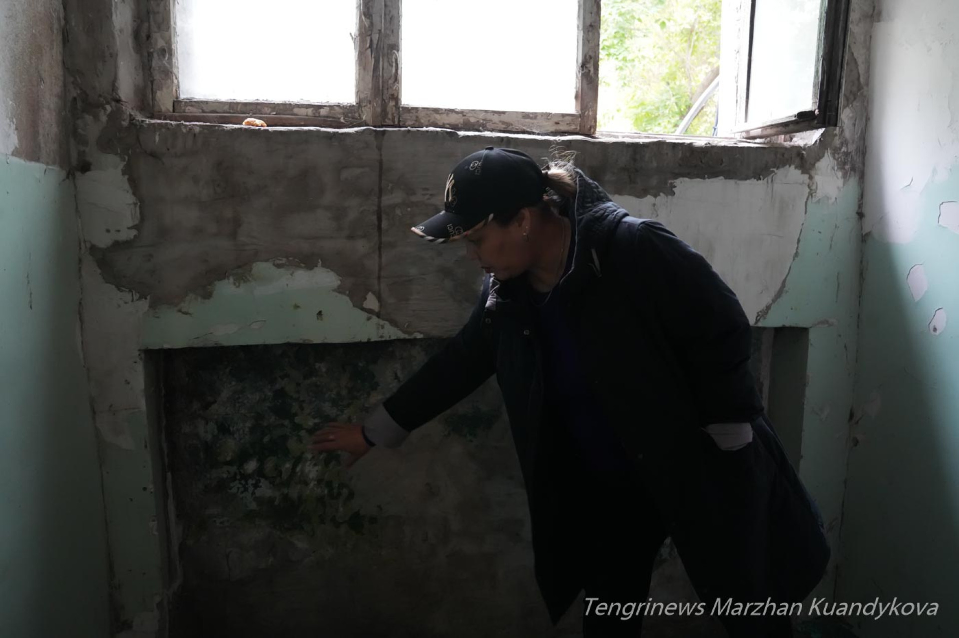 Жительница показывает плесень на стене в аварийном общежитии на Пастера в Астане. Фото: ©️ Tengrinews.kz / Маржан Куандыкова