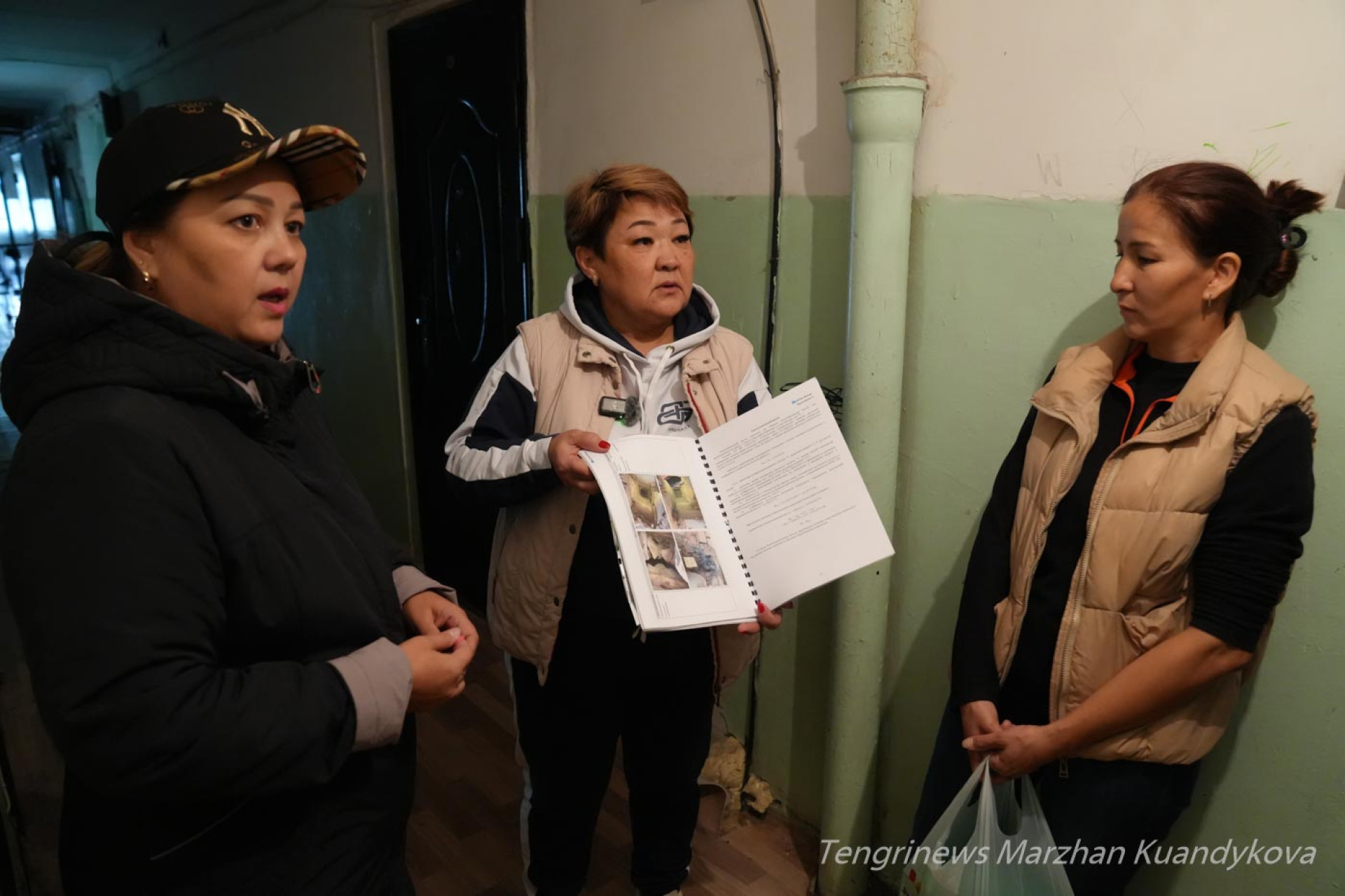 Жильцы аварийного общежития на Пастера в Астане показывают документы