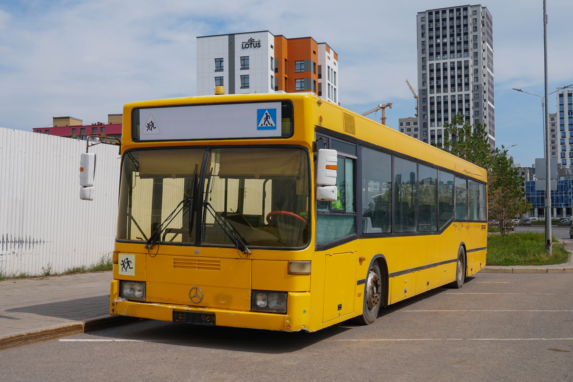 Старый жёлтые автобус постоянно стоит на обочине в Астане