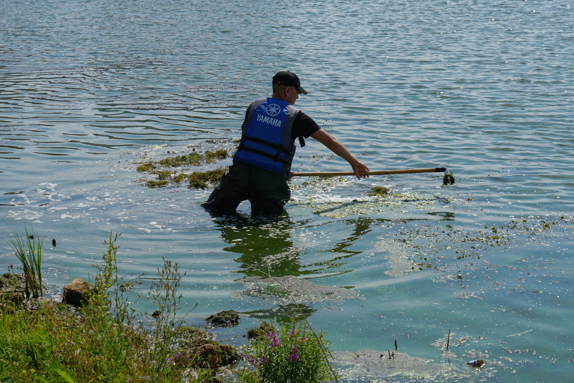 грязная речка в Астане и рабочий, который ее чистит