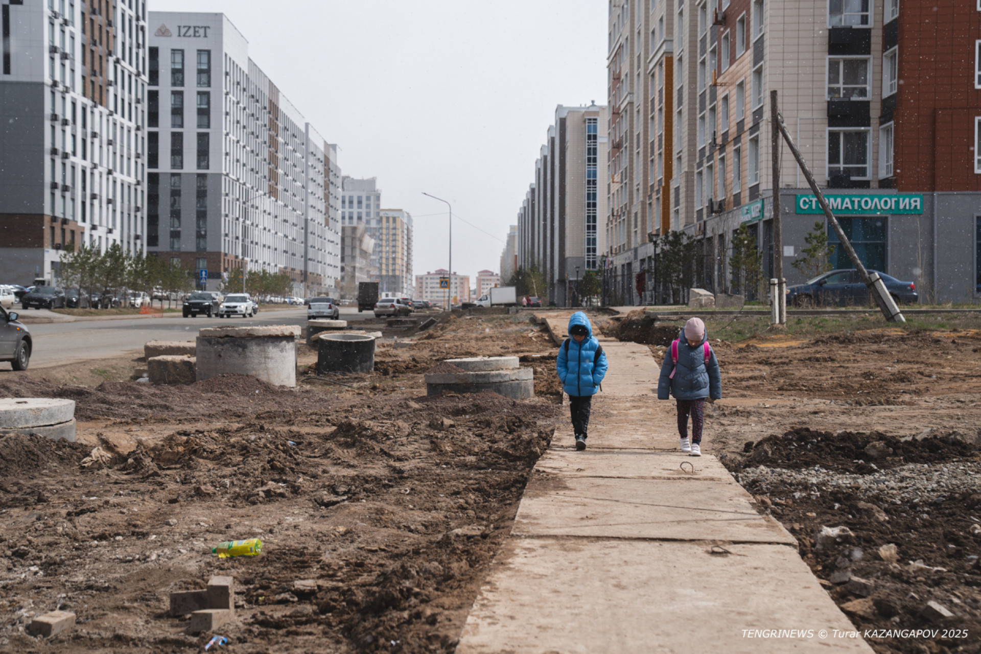 Дети идут по разбитому тротуару среди грязи по Бухар Жырау, апрель 2025 года