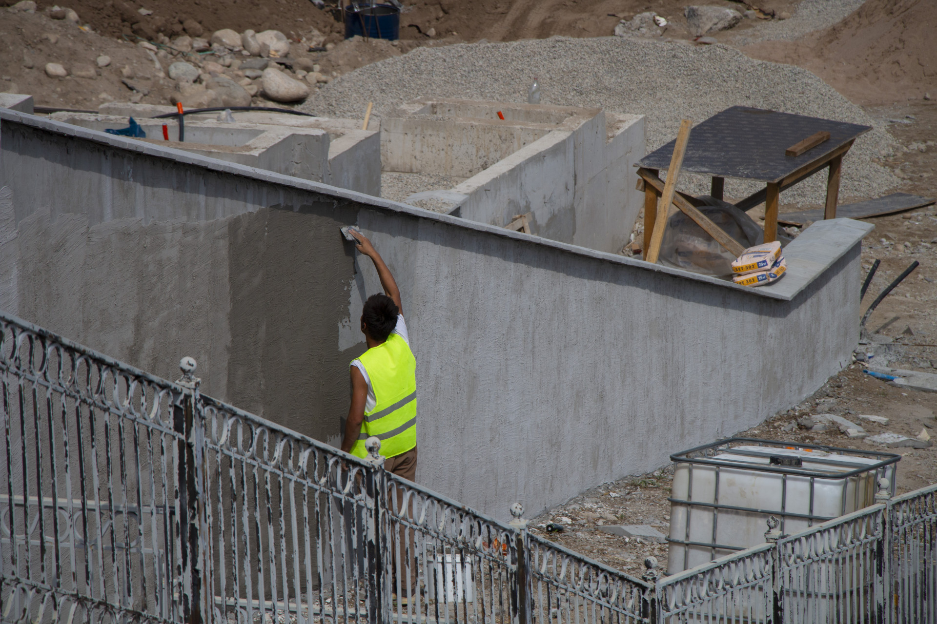 Рабочий шпаклюет каскад на Большой Алматинке, реконструкция, сентябрь 2025 года