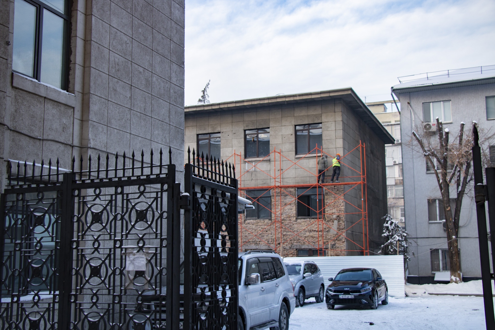 Рабочие снимают плитку со внутренней стороны здания акимата Алмалинского района Алматы, реконструкция, январь 2026 года