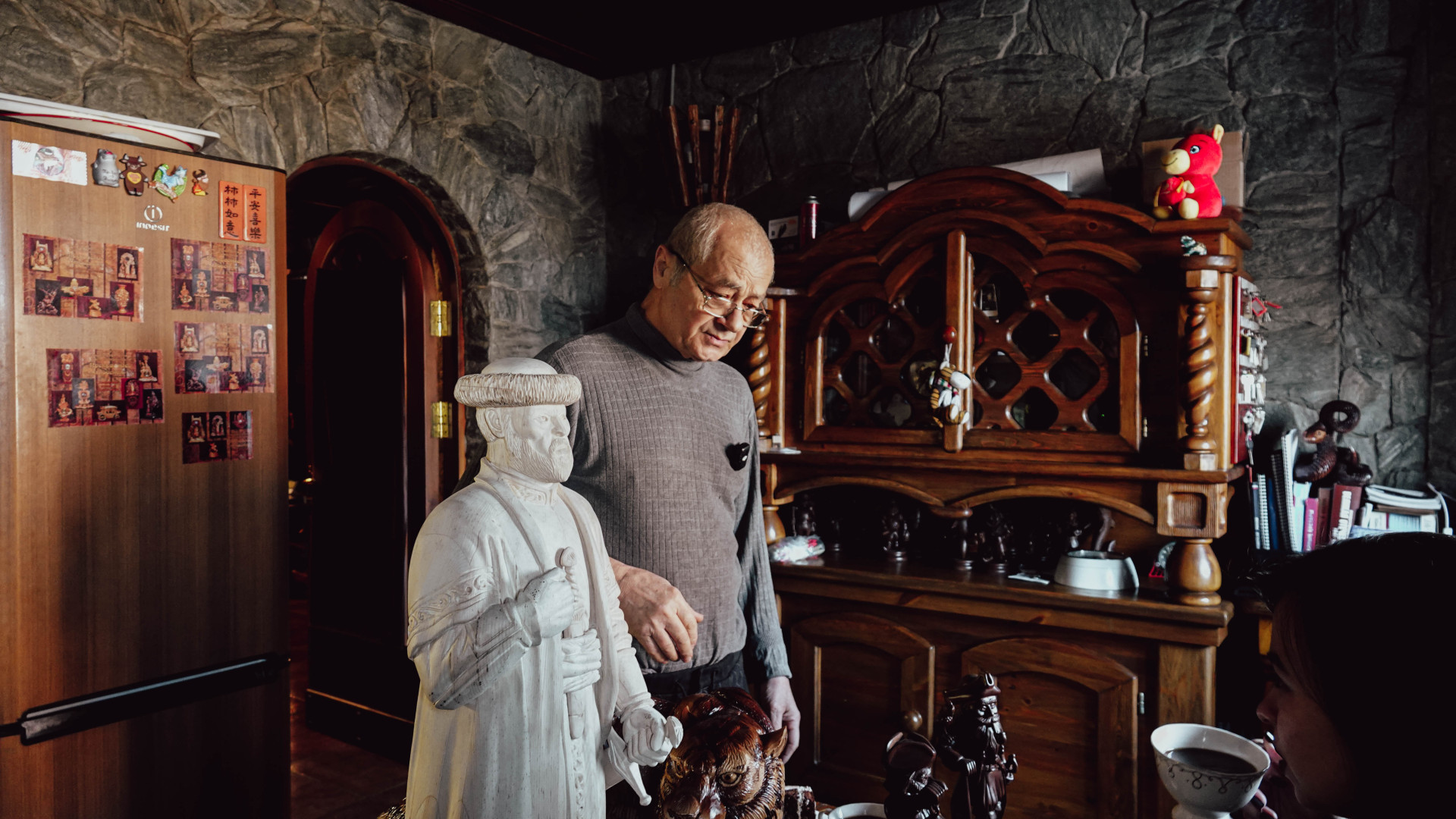 Юрий Костанянц показывает фигуры на кухне своего дома-музея