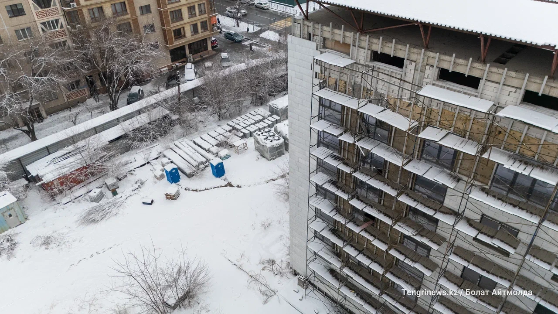 Долгострой: здание суда в Алматы, фото со двора. Стройматериалы, биотуалеты