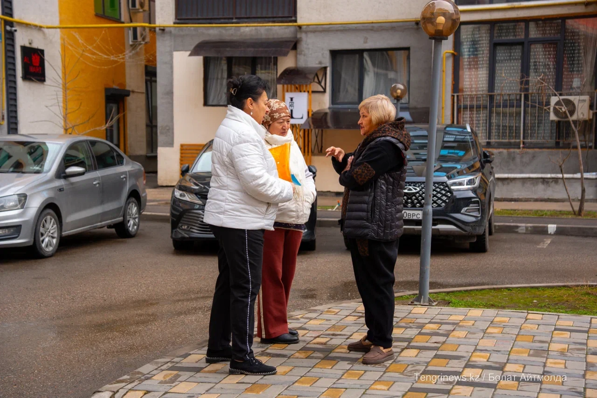 Председатель ОСИ Роза Маманова разговаривает с соседками во дворе